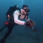 Scuba diver underwater holding rope and marine object