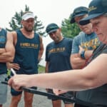 Force Blue team members receiving outdoor briefing with clipboard