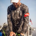 Diver in Force Blue shirt prepares scuba gear on boat