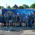 Force Blue team group photo in front of mission trailer
