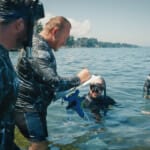 Divers in wetsuits reviewing notes during open water training