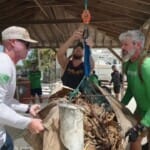 Volunteers weighing collected ocean debris at marina cleanup